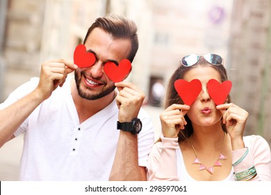 A picture of a happy couple covering eyes with hearts