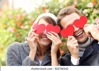 Picture Of Happy Couple Covering Eyes With Hearts