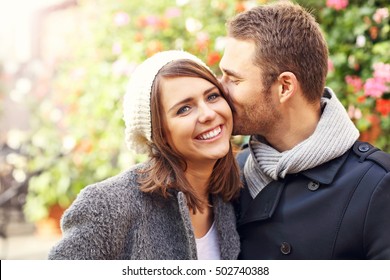 Bild des glücklichen Ehepaares, das sich in der Stadt küsst