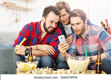 Picture Of Happy Male Friends Cheering And Watching Sports On Tv