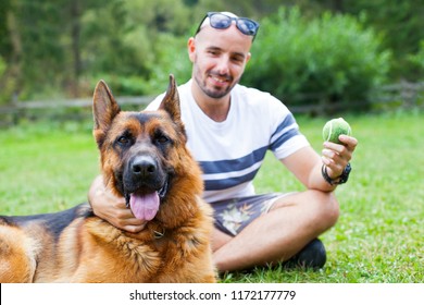 Picture of a happy man playing with his   german shepherd dog - Powered by Shutterstock