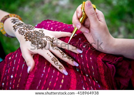 Picture of human hand being decorated with henna Tattoo. mehendi hand