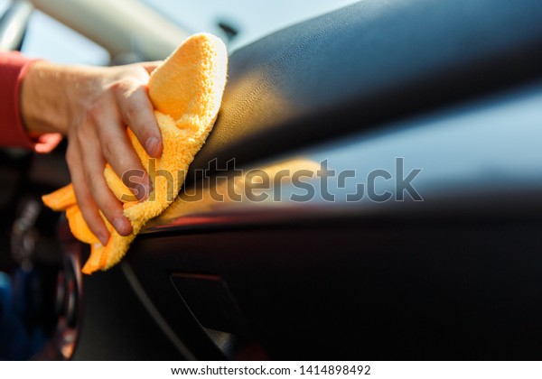 Picture of human hand with orange cloth washing\
machine interior
