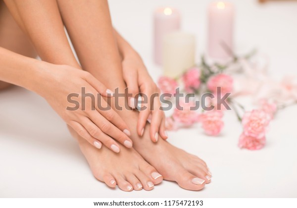 The picture of ideal done manicure and\
pedicure. Female hands and legs in the spa\
spot.