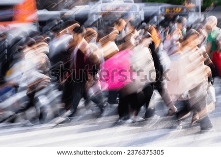 picture with intentional motion blur effect of crowds of people crossing the Shibuya crossing in Tokyo, Japan