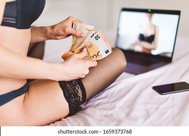 Picture of internet webcam model (cam girl) sitting in front of pc camera with a lot of money - concept of virtual sex chat