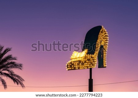 A picture of a large neon shoe, part of the Neon Museum Las Vegas, at sunset.