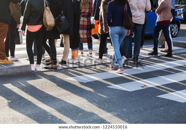 picture of the legs of a crowd of\
people crossing a street at the pedestrian\
crossing