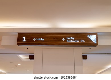 A Picture Of A Lobby And Anrestroom Sign Arrow In A Mall.