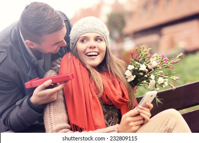 A Picture Of A Man Giving Surprise Gift To Woman In The Park