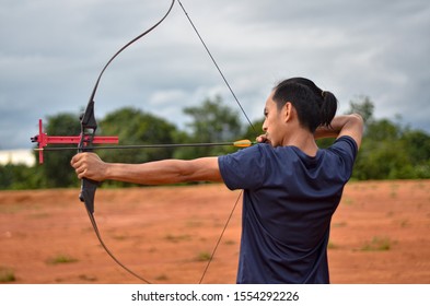 A picture of man pulling the string of the bow to shoot into the target - Shutterstock ID 1554292226