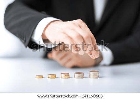 picture of man putting stack of coins into one row