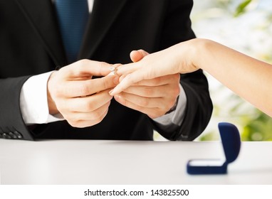 Picture Of Man Putting  Wedding Ring On Woman Hand