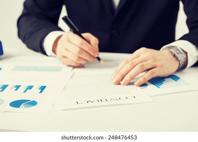picture of man in suit signing contract