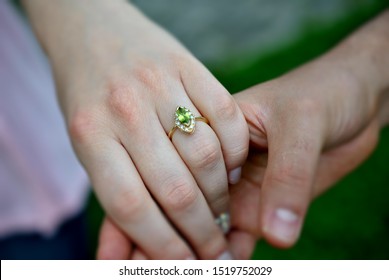 picture of man and woman with engagement peridot and diamonds ring with a natural background