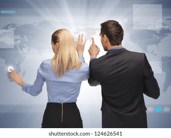 picture of man and woman working with virtual touch screens.