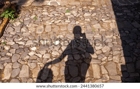 Picture of me taking a photo of my shadow on a cobblestone street.