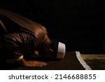 A picture of men perform "sujud" on praying mat during at night. Sign of devout and repent to Allah.