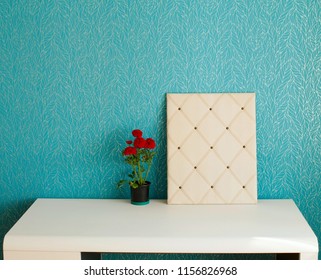 Picture of minimalistic room interior with white table and moodboard flowers on it over blue wall