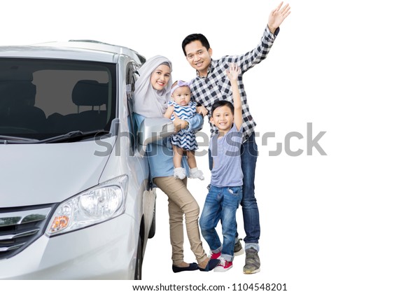 Picture of Muslim\
family standing near their car while waving hands at the camera,\
isolated on white\
background