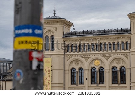 A picture of the Nobel Peace Center and a blurred Hands Off Ukraine sticker on the foreground.