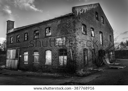 Picture of an old abandoned building sitting in a desolate countryside