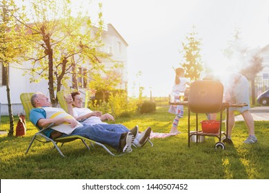 Picture of older couple lying down in chairs in their backyard and enjoining after good barbeque - Shutterstock ID 1440507452