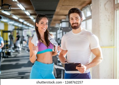 Picture Of Personal Fitness Trainer And His Female Client In Gym Posing In Front Of The Camera.