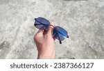 picture of a photochromic lens during the day under the hot sun held by hand