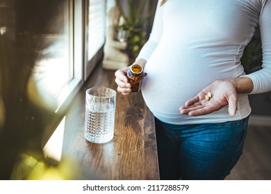 Picture Of Pregnant Woman Taking Medication Pills. Pregnant Woman Taking Pill Against Heartburn. A Young Pregnant Woman Is Taking Medications And Drinking Water.