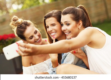 Picture presenting happy group of friends with smartphones sitting outdoors - Shutterstock ID 453680137