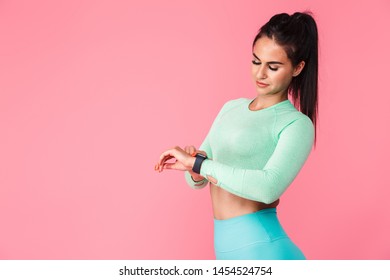 Picture Of Pretty Young Sports Fitness Woman Isolated Over Pink Wall Background Using Watch Clock.