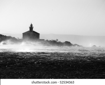 Picture represents the lighthouse while blowing strong wind.Picture is made in black white.