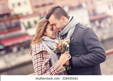 Una imagen de una pareja romántica con flores en un paseo de otoño