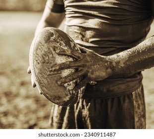 A picture of rugby players with a rugby ball, men playing, a stadium with rugby field, cheering fans, and lush green turf. - Powered by Shutterstock