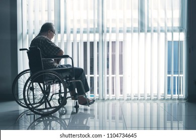 Picture Of Sad Elderly Man Sitting In The Wheelchair While Looking Out The Window In The Retirement Home