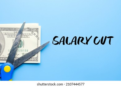 A Picture Of Scissors And Fake Money With The Word Salary Cut.