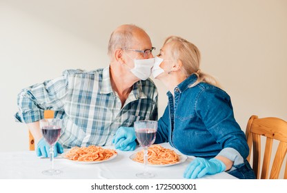Picture of senior couple kissing with masks during dinner wearing blue latex gloves - concept of life with COVID (coronavirus), romantic usage of personal protective equipment at restaurant - Powered by Shutterstock