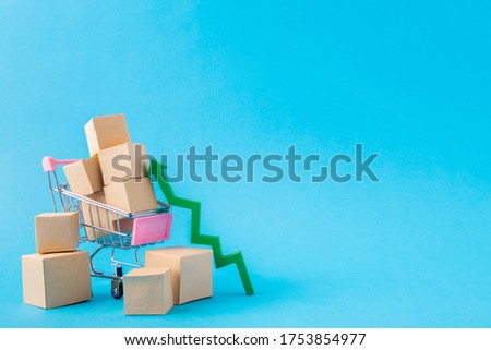 Picture of shopping cart carrying large parcels arrow going up developing export sales management online boutique isolated over bright vivid shine vibrant blue color background