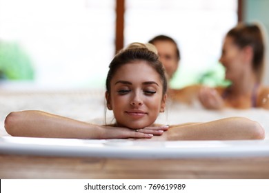 Picture showing group of friends enjoying jacuzzi in hotel spa