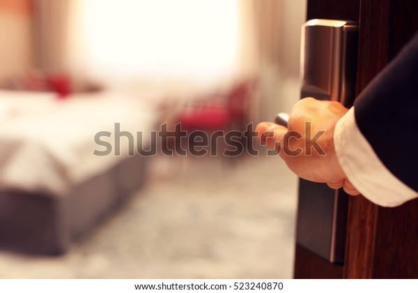 Picture\
showing hand of businessman opening hotel\
room