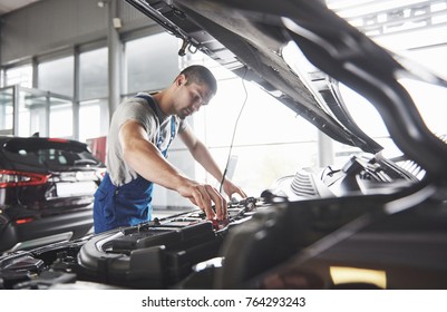 Picture Showing Muscular Car Service Worker Repairing Vehicle.