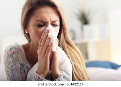 Picture showing sick woman sneezing at home