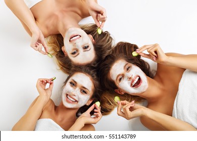 Picture showing three friends with facial masks over white background