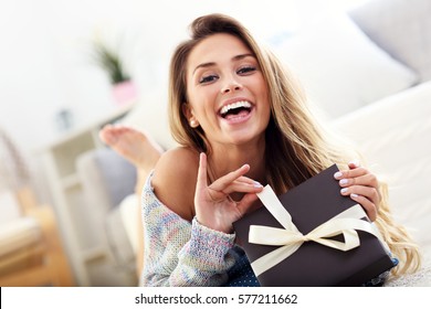 Picture Showing Woman Opening Present On Carpet