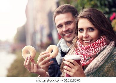 Picture Showing Young Couple On Date In The City With Coffee And Donuts