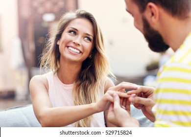 Picture showing young man proposing to beautiful woman outdoors