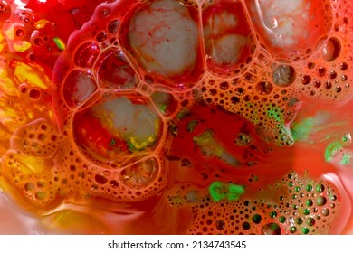 The picture shows a texture pattern created on a red background with large and small soap bubbles.