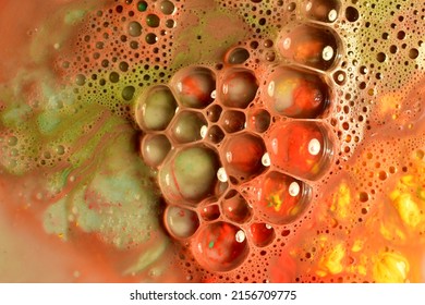The picture shows a texture pattern created by transparent soap bubbles on a brownish-green background.