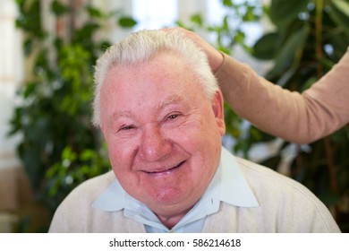 Picture of a smiling elderly man at home with his caregiver